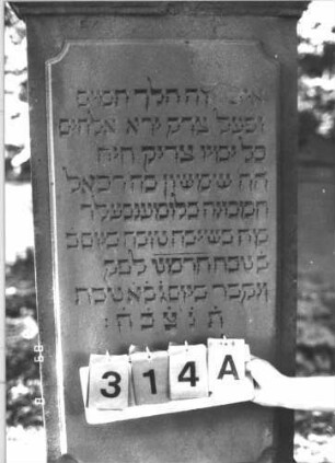 Grabstein 314 (Index: 99609951) Material: Sandstein Zustand: verwittert Maße HxBxT: 217x68x30 cm Beschreibung: Stele, Abdeckplatte, Giebelaufsatz mit Seitenakroteren, Schriftfeld erhaben, getreppter Sockel: Grabstein 314A
