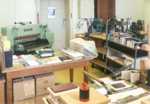 Sächsische Landesbibliothek - Staats- und Universitätsbibliothek Dresden. Zentralbibliothek (ehem. Landesbibliothek). 2. Obergeschoss. Abteilung Bestandserhaltung, Buchbinderei, Teilansicht mit Schneidemaschine : Dresden-Neustadt, Marienallee 12. Sächsische Landesbibliothek - Staats- und Universitätsbibliothek Dresden. Zentralbibliothek (ehem. Landesbibliothek). 2. Obergeschoss. Abteilung Bestandserhaltung, Buchbinderei, Teilansicht mit Schneidemaschine