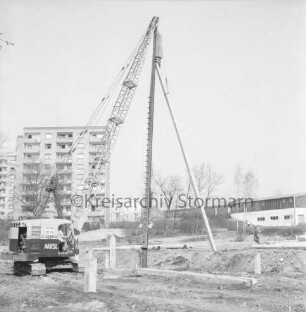Sülzberg: Bau mehrgeschossiger Wohnblocks: Ramme beim Setzen von Pfählen: rechts daneben Arbeiter: dahinter Hochhäuser am Kurpark: hinten rechts Wohngebäude und Betriebsgelände der Maschinenfabrik Lythall KG
