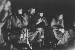 Höfgen. Akt-Pleinair 1979. Ein unbekannter Fotograf und mehrere junge Frauen sitzen am Lagerfeuer