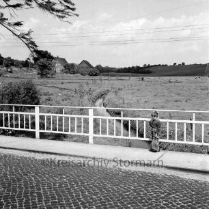Norderbeste: Blick von der Brücke der Bundesstraße B 75 mit alter Straßenführung auf das Unterdorf: rechts Kind am Geländer