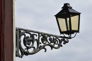 Kleinstadt Nora - Historische Straßenlaterne : Reich verzierte historische Straßenlaterne an einem Holzhaus, aufgenommen in der Kleinstadt Nora am 26. Juli 2012