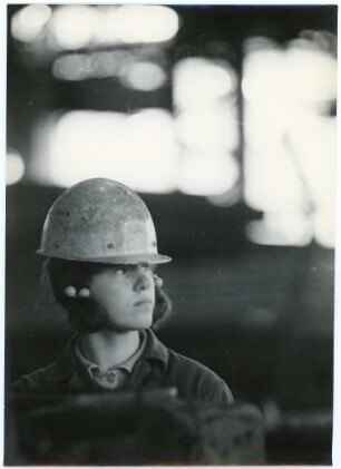 Junge Industriearbeiterin mit Helm