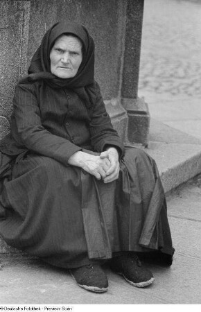 Porträt einer alten Frau an einem Brunnen