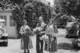 Reisefotos Madeira. Der Fotograf Franz Grasser und zwei Frauen in Tracht, Blumensträuße haltend
