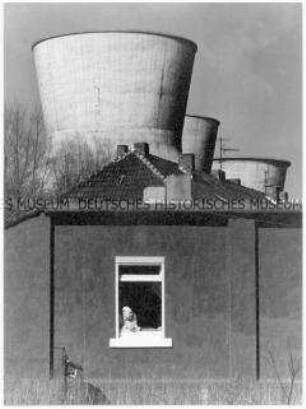 Mann schaut aus dem Fenster, im Hintergrund drei große Kühltürme (Altersgruppe 18-21)