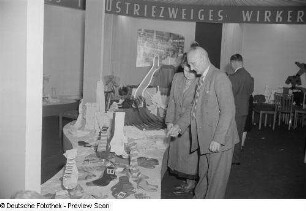 Besucher an einem Messestand mit Textilien (Strümpfe)
