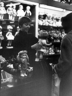 Hamburg-Altstadt. Speersort/Ida -Ehre-Platz. Hier befand sich das schönste Spielzeuggeschäft der Freien- und Hansestadt - Spielzeug Rasch. Eine Verkäuferin berät eine Kundin beim Kauf einer Puppe