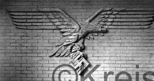 Adlerrelief: fliegender Adler, in Fängen Hakenkreuz: an Backsteinwand: Nahaufnahme;