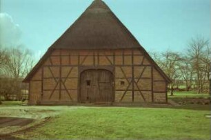 Fachwerkhaus mit Reetdach: Giebelseite Wirtschaftstrakt mit Scheunentor