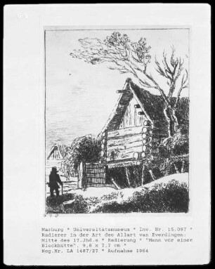 Mann vor einer Blockhütte