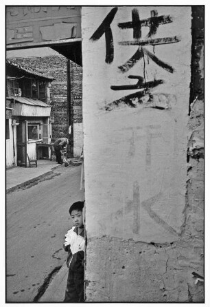 China. Kind an einer Hausecke