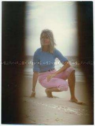 Junge Frau kniet am Strand