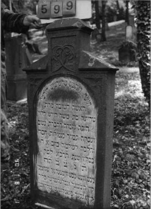Grabstein 599 (Index: 99790839) Maße HxBxT: 131x60x16 cm Symbolik: Levitenkanne Besonderheit: kulturhistorisch wertvoll / hist.-wiss. Gründe (Gemeindestellung): Grabstein 599