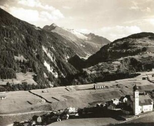 Disentis/Mustér. Tal des Vorderrheins (Rein Anteriur). Blick vom Klosterberg über die Hauptkirche St. Johann der Täufer in das Tal des Medelser Rheins (Rein da Medel, Mittelrhein)