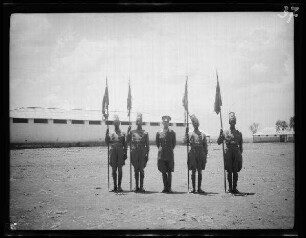 Godefelazzi (=Godew, Eritrea): Graf Branca Offizier inmitten von 4 einheimischen Fahnenträgern ("Standarten") auf dem Exerzierplatz der italienischen "Eingeborenenkavallerie" das Kommandanten Major Barone Branca