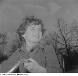 Ein Mädchen mit Schulranzen auf einem Fahrrad