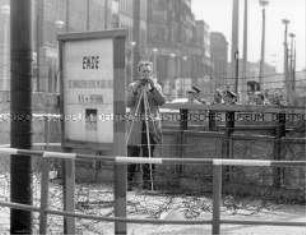 Ein Fotograf in der Sperrzone am Potsdamer Platz beobachtet den Besuch Konrad Adenauers