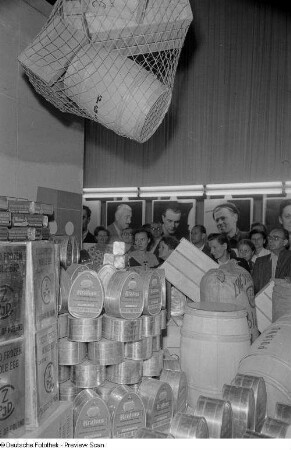 Besucher der Herbstmesse 1953 an einem Stand mit polnischen Fleischkonserven