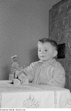 Kleiner Junge, mit Schachteln spielend