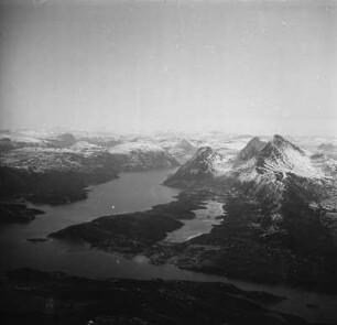 Luftbildaufnahme eines Fjords : Durch Gletscher geformte Landschaft. Links das Gewässer eines Fjords.