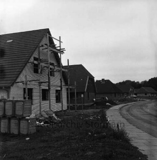 Oetjendorfer Kirchenweg: Neubaugebiet mit Eigenheimen: vorn links Rohbau mit Gerüst: davor Baumaterial: hinten Mitte und rechts Häuser vor und nach Fertigstellung: davor Lieferwagen und Pkw