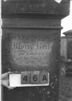 Grabstein 46 (Index: 99609682) Material: Sandstein Zustand: verwittert, Schriftplatte fehlt Maße HxBxT: 190x65x30 cm Beschreibung: Stele, Abdeckplatte mit Giebelaufsatz, Seitenakrotere, rechteckige Schriftplatte fehlt, getreppter Sockel: Grabstein 46A