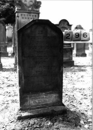 Grabstein 296 (Index: 99797838) Material: Sandstein, weiß Zustand: stark verwittert Maße HxBxT: 97x47x11 cm Beschreibung: Stele, giebelartiger Abschluß abgeflacht, Sockel: Grabstein 296