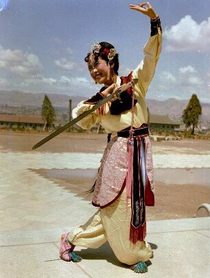 Schwerttänzerin in traditioneller Kleidung und in Bewegung (China 1959)