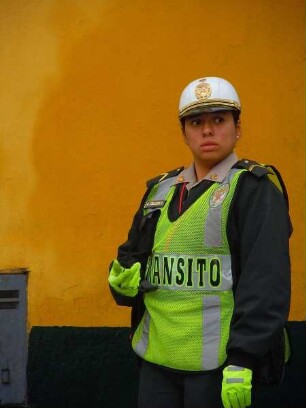 Lima - Verkehrspolizistin im Zentrum : Eine Verkehrspolizistin steht vor einer gelben Hauswand. Aufgenommen am 27. August 2011 in der Hauptstadt Lima