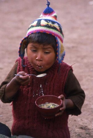 Indiojunge isst aus einer Schale : Indiojunge in den Anden in Peru, 1990