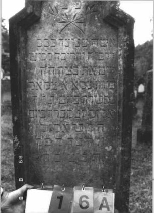 Grabstein 16 (Index: 99799585) Material: Sandstein Zustand: stark verwittert Maße HxBxT: 170x55x28 cm Beschreibung: Stele, schräg eingezogener Rundbogenabschluß, Schriftfeld eingetieft, getreppter Sockel mit eingetieftem Schriftfeld Symbolik: floral: Grabstein 16A