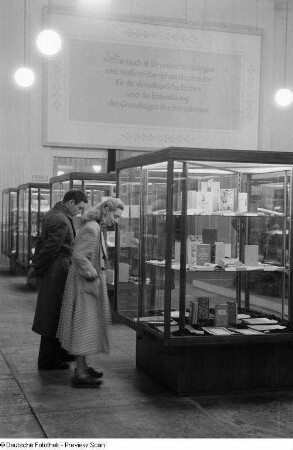 Besucher betrachten die in Vitrinen ausgestellten Exponate bei der 2. Deutschen Buchkunst-Ausstellung