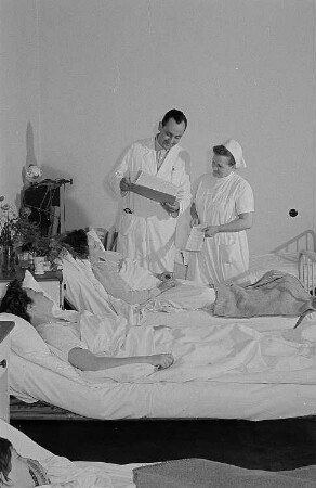 Ein Arzt, eine Krankenschwester sowie drei Patientinnen bei der Visite in der Betriebspoliklinik der Transmasch Leipzig