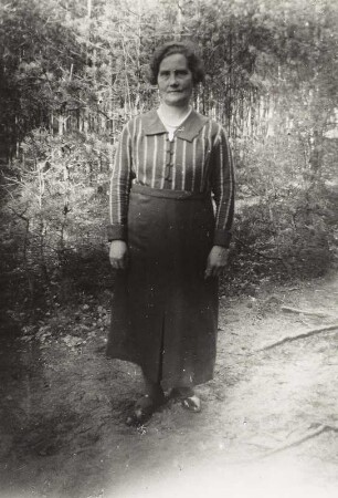 Frau im Tageskleid in einem Garten stehend