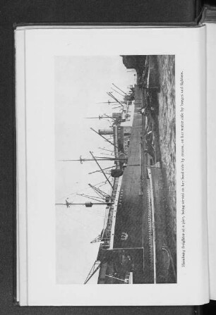 Hamburg freighter at a pier, being served on her land side by cranes, on her water side by barges and lighters.