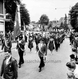 Schützenfest: Veranstalter Ahrensburger Schützengilde: Am Alten Markt: Umzug: Fahnenabordnung der Schützengilde marschiert, dahinter Vereine: an beiden Straßenseiten Zuschauer: im Hintergrund rechts Schlosskirche und Gottesbuden, links parkende Autos