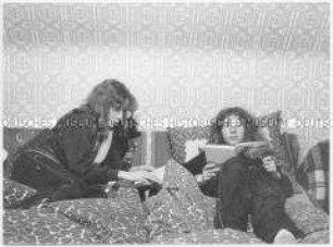 Zwillinge beim Lesen im Bett (Altersgruppe 14-17)