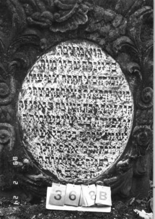 Grabstein 368 (Index: 99752590) Material: Sandstein Zustand: leicht verwittert Maße HxBxT: 176x92x13 cm Beschreibung: Stele, geschwungener Abschluß mit Mittelakroter, ovales Schriftfeld Symbolik: Muschel, Blüten, Blätter, Ranken, Voluten, Schriftband: Grabstein 368B