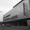 Nickel: Mühlenstraße / Lübecker Straße: Kaufhaus: Einrichtungshaus Lübecker Straße: Fassade aus Aluminiumblech, mit Firmenname: Eröffnung nach Erweiterung und Umbau: rechts Bauzaun, Bauschild: Straße, parkende Autos