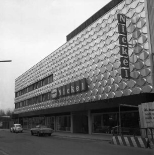 Nickel: Mühlenstraße / Lübecker Straße: Kaufhaus: Einrichtungshaus Lübecker Straße: Fassade aus Aluminiumblech, mit Firmenname: Eröffnung nach Erweiterung und Umbau: rechts Bauzaun, Bauschild: Straße, parkende Autos
