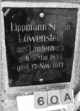 Grabstein 60 (Index: 100116187) Material: Stele: Sandstein, Schriftplatte: Granit Zustand: gut Maße HxBxT: 170x62x21 cm Beschreibung: Stele mit eingezogenem Rundbogenabschluß und getrepptem Sockel, aufgesetzte Schriftplatte Symbolik: Blumenornamentik: Grabstein 60A