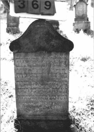 Grabstein 369 (Index: 100106665) Material: Sandstein Zustand: stark verwittert, weitgehender Textverlust Maße HxBxT: 80x41x9 cm Beschreibung: Stele mit geschwungenem, überkragendem Bogenaufsatz, Sockel Besonderheit: Kindergrab: Grabstein 369