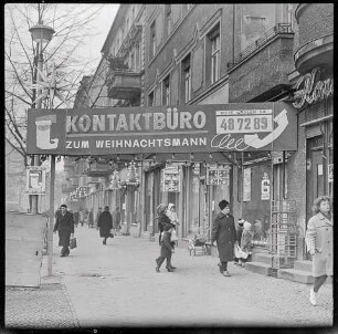 Straßenszene mit Plakat "Kontakt zum Weihnachtsmann", 1967. SW-Foto © Kurt Schwarz.