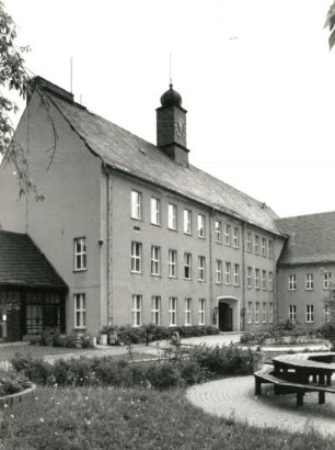 Schwarzenberg. Schule mit Turnhalle (ehemalige Fachschule des Waschgerätewerkes), Am Hofgarten 5 (1956). Schulgebäude. Ansicht aus einer Grünanlage