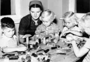 Arbeitsmaid des Reichsarbeitsdienstes bei der Kinderbetreuung im Kindergarten - Lindengarten