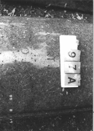 Grabstein 97 (Index: 100105788) Material: ?, Kranz auf Metall Zustand: sehr gut Maße HxBxT: 61x77x169 cm Beschreibung: Sarkophag Symbolik: Kranz Besonderheit: kulturhistorisch wertvoll / künstl.-formale Gründe (Stein): Grabstein 97A