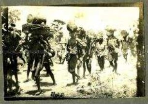 Afrikanische Träger mit Kopflasten beim Marsch, Deutsch-Ostafrika