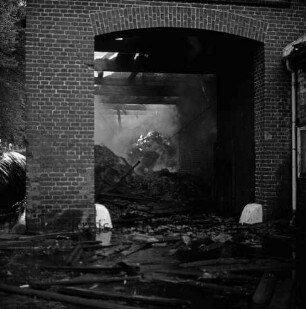 Gut Altfresenburg: Brand des Bullenstalls: Brandruine: Blick durch ein Tor in den Innenraum: hinten brennendes Heu und Rauchschwaden: 24. August 1971