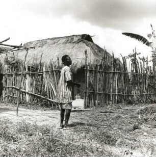 Ghana. Dorf in der Savanne in Ghana. Einwohner vor eingezäunter Hütte